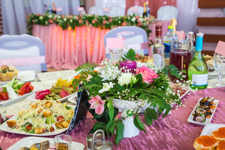 Served tables at the Banquet. Drinks, snacks, delicacies and flowers in the restaurant. A gala event or wedding.の写真素材