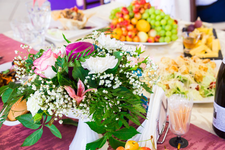Served table at the Banquet. Fruits, snacks, delicacies and flowers in the restaurant. Solemn event or wedding.の写真素材