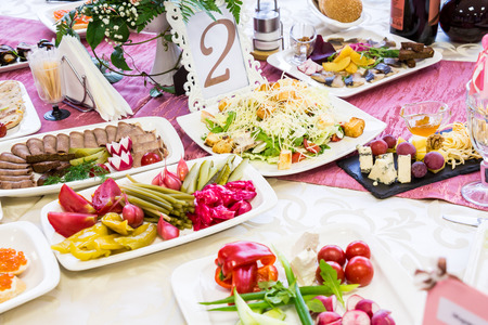 Served tables at the Banquet. Drinks, snacks, delicacies and flowers in the restaurant. A gala event or wedding.の写真素材