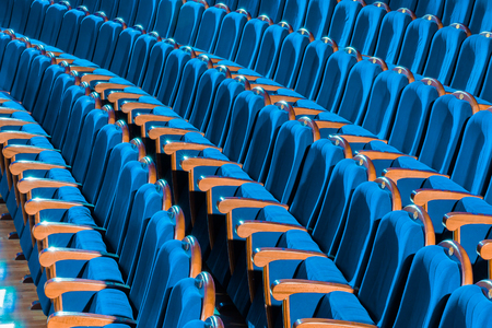 Blue plush chairs with wooden armrests in the auditorium. Empty auditorium in the theater.の写真素材