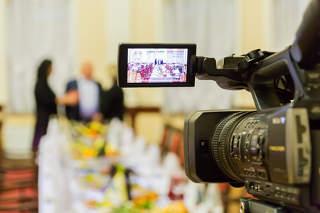 Video shooting at a restaurant at a Banquet. Camcorder with LCD display. People in the hall.の写真素材