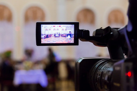Video shooting at the restaurant. Digital video camera with LCD display. At the background. Defocused background.の写真素材
