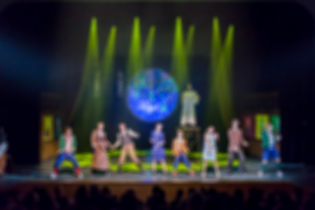 Artists on stage at the end of the performance. The audience in the auditorium. Light rays from the...