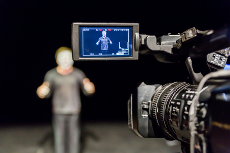 Actor in front of the camera. LCD display on the camcorder. Filming in the interior.の写真素材