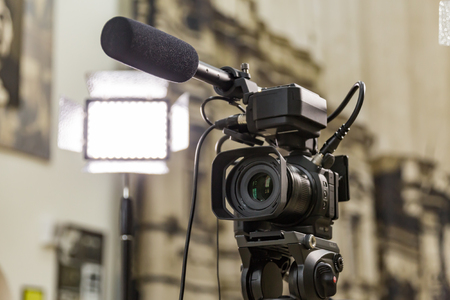Shooting a report in the interior. Video equipment: camera, on-camera microphone gun, led lighting device, tripod.の写真素材