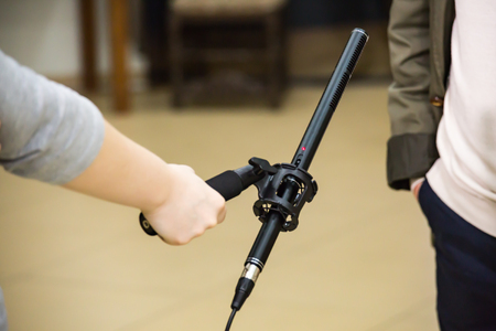 Condenser Shotgun Microphone. A woman interviews a man. The microphone in the reporter's hand.の写真素材