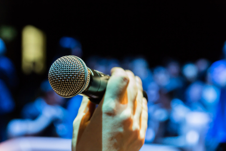 Wireless microphone in hand. Blurred image in the background.の写真素材