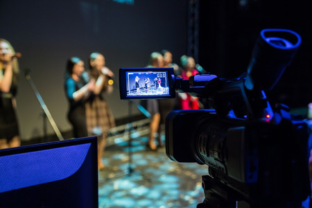 Video recording of the concert. Girls sing in microphones. Camcorder with LCD display. Shooting in the interior, Studio or on stage.の写真素材
