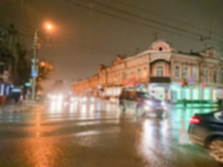 Defocused abstract image. Bokeh effect. Blurred background. Evening cityscape in rainy weather. Cars and night lights. City of Saratov, Russia.の写真素材
