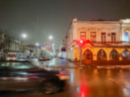 Defocused abstract image. Bokeh effect. Blurred background. Evening cityscape in rainy weather. Cars and night lights. City of Saratov, Russia.の写真素材