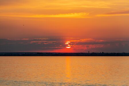 Sunset on the Volga river in Russia in July. Orange sun in the sky. Picturesque nature. Summer evening. River cruise.の写真素材