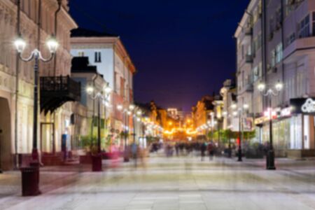 Defocused image, bokeh effect. Evening or night cityscape. Long exposure. People walk on a pedestrian street. Nizhny Novgorod, Russia.の写真素材