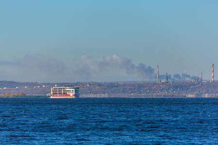 Saratov, Russia - October 21, 2020: The motor ship "Mustai Karim" of the PV300 project of the Vodohod cruise company on the Volga River. Industrial enterprises are on the horizon. A sunny autumn day.のeditorial素材