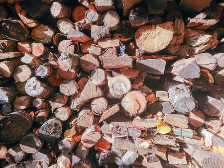 A stack of firewood for the stove in the courtyard of a village house. Wooden texture.の写真素材