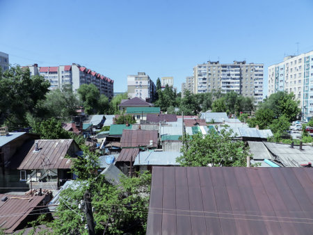 A sleeping area of a Russian provincial town. Multi-storey residential buildings. Old wooden private houses.の写真素材