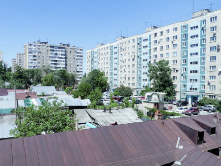 A sleeping area of a Russian provincial town. Multi-storey residential buildings. Old wooden private houses.の写真素材