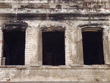 A crumbling old brick house. empty windows.の写真素材