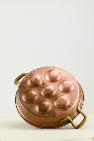 old copper pot for eggs isolated verticalの写真素材