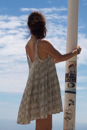 young woman in a light summer clothes looking to the skyの写真素材