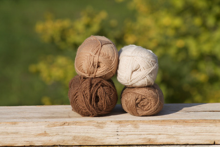 balls of wool in shades of natural tones on old woodの写真素材