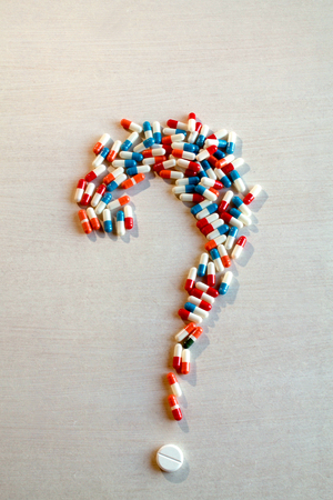Pills and capsules forming a question mark, verticalの写真素材