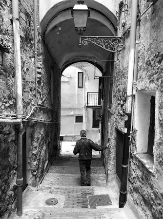 ITALY, SANREMO - MAY 6, 2017 old man goes down the stairs in  characteristic alleyのeditorial素材
