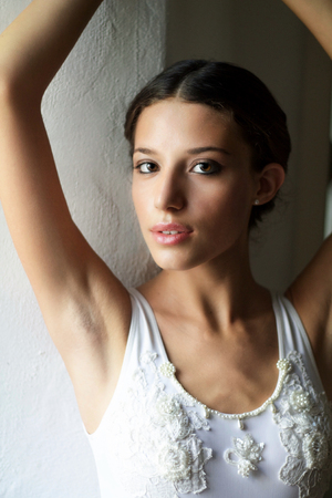 portrait of beautiful young woman in white dress looking at camera intenselyの写真素材