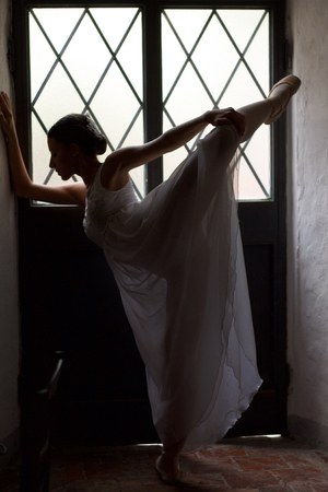 ballet dancer silhouette doing  warm up before performance in stage costumeの写真素材