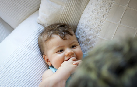 baby boy laying down  head  portrait smiling and interacting with mom