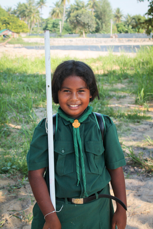 Kho Lipe, THAILAND - january 10, 2013:portrait of a smiling thai  student coming out of school in traditional green uniform, kho Lipe island, Thailandのeditorial素材