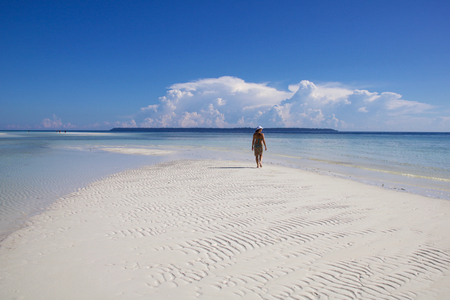 one woman walking on the sand in bikini and pareo, idyllic tropical seascapeの写真素材