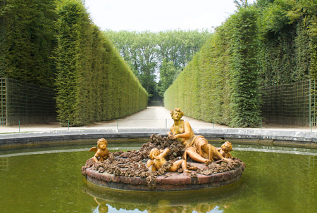 VERSAILLES, FRANCE - July 20, 2016:  one of the several fountains in the gardens of  Versailles Palace with golden statues in a  pond, flora fountain, horizontalのeditorial素材