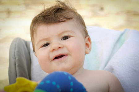 close up of baby boy face with joy expression looking at cameraの写真素材