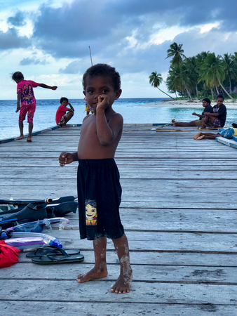 WEST PAPUA, RAJA AMPAT - August 28, 2017: asian child with fingers in the nose  playing with others children on a wooden pier  in Fam island, Raja Ampat archipelagoのeditorial素材