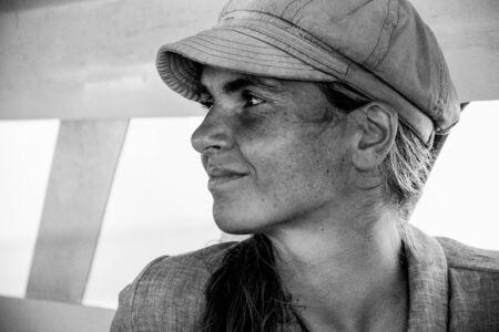 maratua island, Kalimantan - August 31, 2018: close  portrait of a beautiful young woman  with cotton hat traveling on boat for tourism, black and whiteのeditorial素材