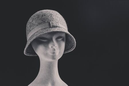 grey female hat on mannequin head, space for text, black and white