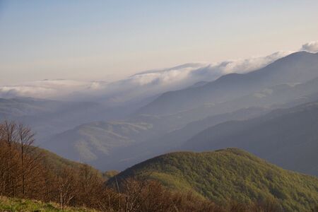 mountains peaks on the mist and clouds at sunset