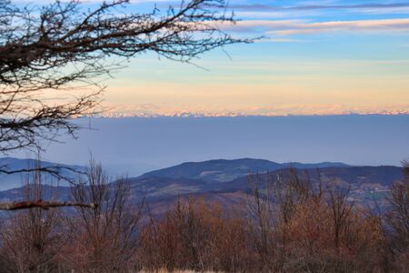 smog strip under  the snowy mountains in winterの写真素材