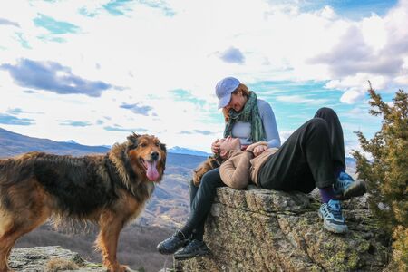 mother and daughter sitting close together  smiling and family dog, tenderness conceptの写真素材
