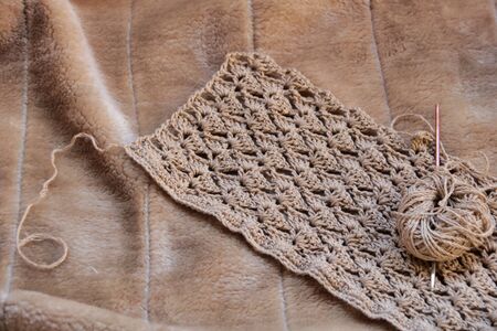 close up of crochet pattern on a faux fur plaid background