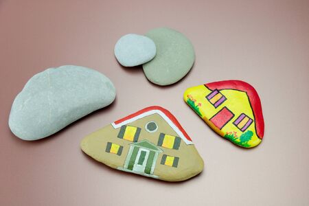 painted stones as homes and natural stones isolated on pink. leisure activity for childrenの写真素材