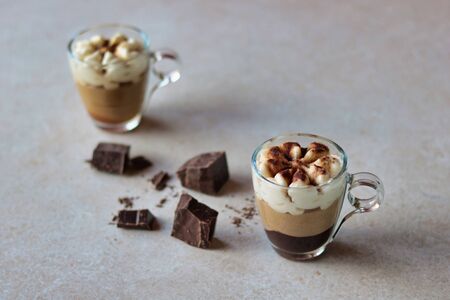 two coffee cream cups with cocoa powder on a white background