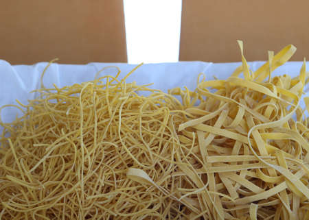 close up of dry homemade fettuccine and spaghetti ina basket