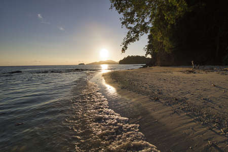 reflection of sunlight on the sea and on the sand at tropical sunrise
