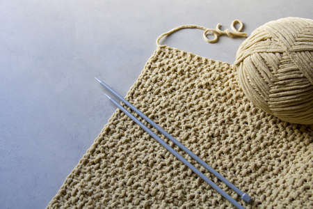 part of knitted work in beige soft yarn, gray backgroundの写真素材