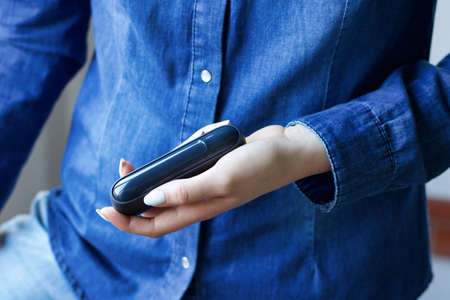 female hand holding charger of electronic cigarette, copy space