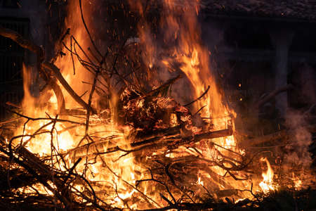 close up of large burning bonfire with sparkles flying in the nightの写真素材