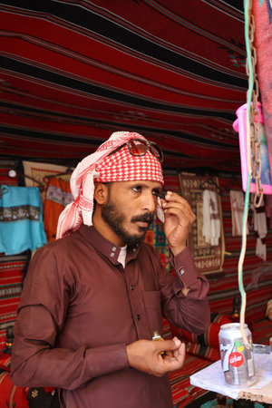 little petra, Jordan - August 30, 2022: unknown bedouin man under a tent putting black kajal on his eyes in front of a mirrorのeditorial素材