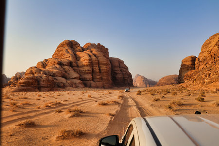 offroad vehicle with tourists visiting wadi rum desert at sunset, jordanの写真素材