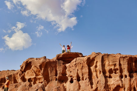 two woman tourists smiling on top of rock formations in wadi rum desert, Jordanの写真素材